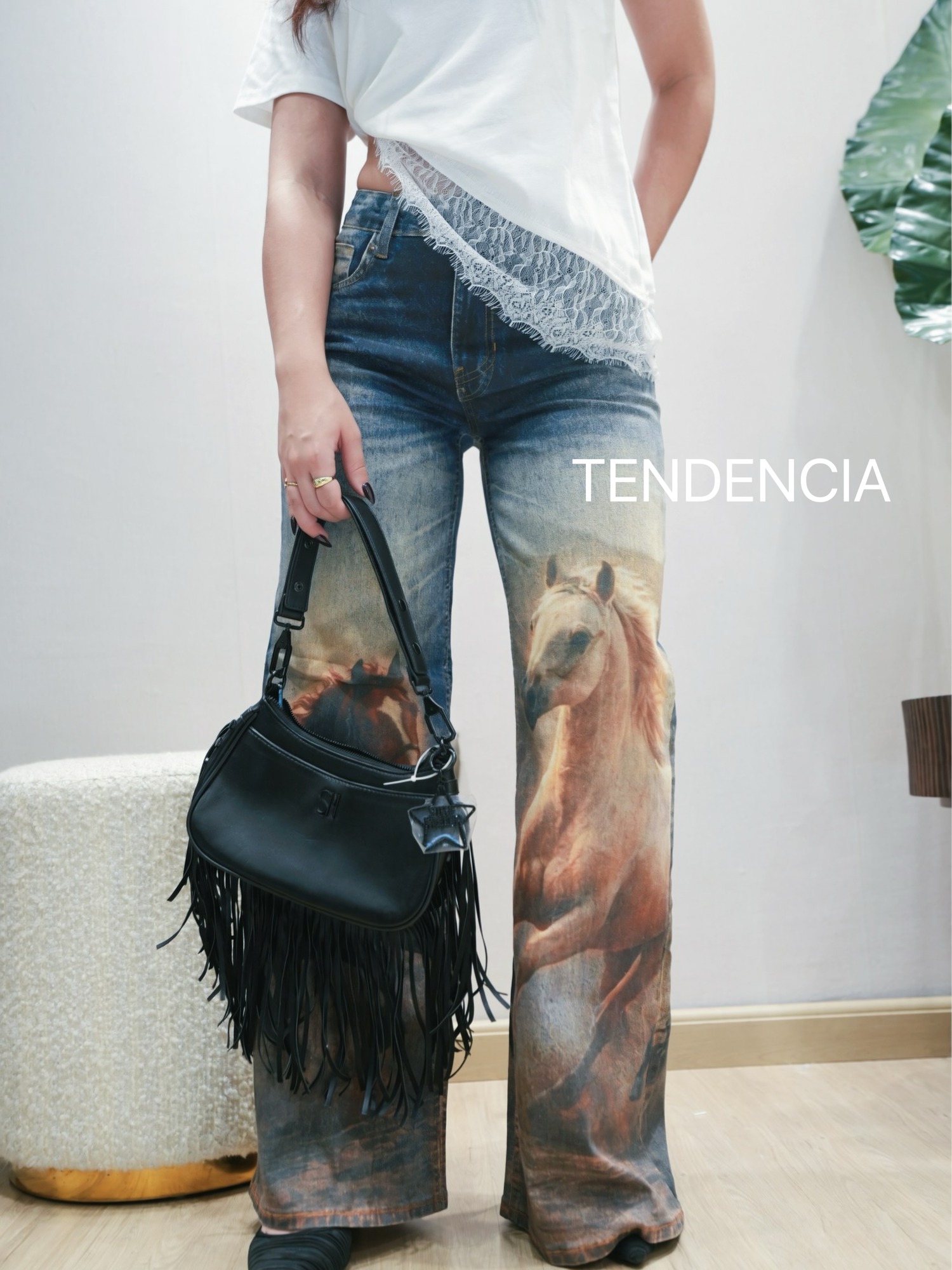 Jeans acampanados con estampado de caballos y la etiqueta TENDENCIA